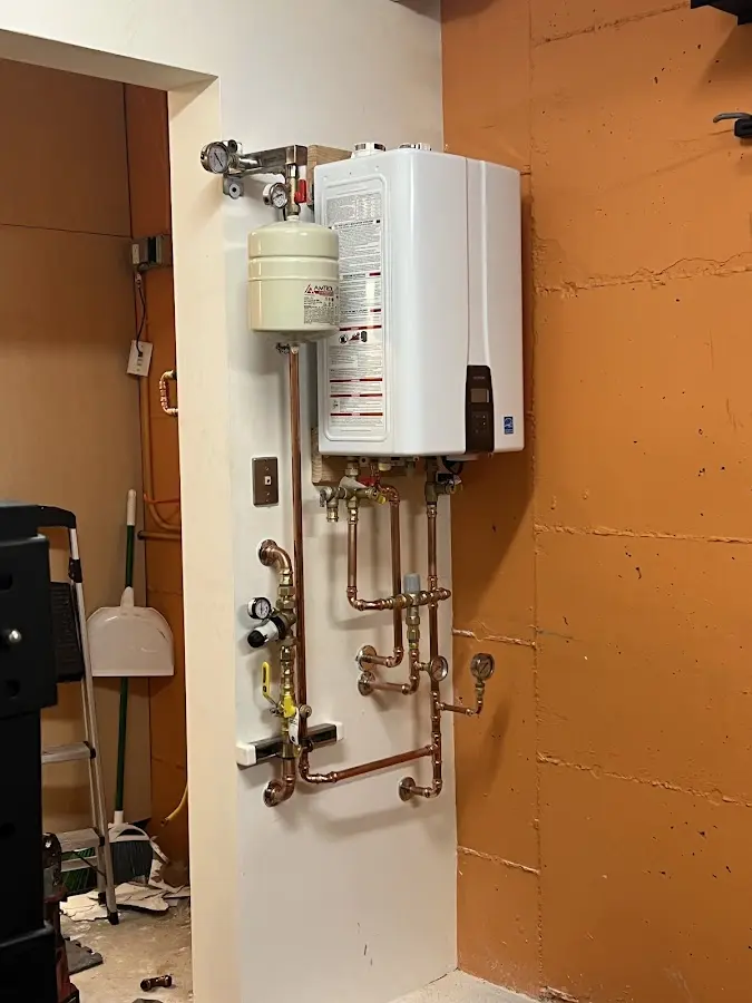Plumbing technician inspecting water heater connections in Huntington Woods